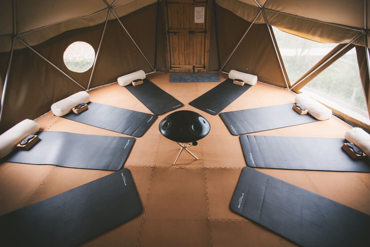 Circle of yoga mats neatly arranged inside the Soul Sweats canvas dome, ready for a calming breathwork and movement session.
